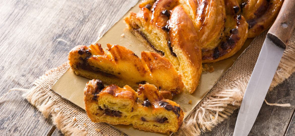 homemade-braid-stuffed-with-chocolate-and-cut-into-pieces-on-wooden-table